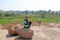 Bald Man is a tourist and photographer in Hampi, sits on a rock and looks into the distance. Large stones Hampi on the side of the