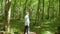 Bald man walks through the forest, green trees, summer, nature. Full shot.