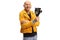 Bald man in a yellow jacket smiling and holding a vintage recording camera