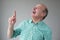 Bald mature hispanic man looking up pointing up laughing.