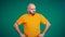 Bald middle-aged man with a beard in an orange t-shirt chews and wrinkles. The man doesn\'t like the food.