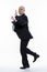 A bald middle-aged man in a strict black suit jumps funny. Business success. Full height. White background. Vertical