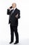 A bald middle-aged man in a strict black suit is standing and talking on the phone. Business success and complexity. White