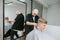 Bald professional barber cuts a young man with a clipper in his hands. Barber creates a stylish hairstyle for a young man with