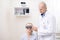 Bald professional ophthalmologist examining eyesight of young female patient
