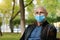 Bald senior man in medical protective face mask looks at the camera