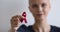 Bald woman showing to camera red symbolic awareness ribbon