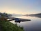 Baldeneysee lake just before sunrise. A small, moored motorboat on the lake covered with a cover