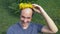 Balding man with a wreath of dandelions on his head. looking at the camera