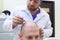 Baldness treatment. Patient suffering from hair loss in consultation with a doctor. Preparation for hair transplant