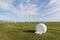Bale of fodder grass wrapped in white plastic lying on the field in Iceland