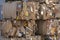 Bales of cardboard and box board with strapping wire ties. Background of paper textures piled ready to recycle.