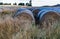 Bales of hay on a Barley field with a backdrop of the Southern Alps at sunset in Wanaka Otago New Zealand