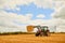 Bales of hay. a farmer stacking hale bales with a tractor on his farm.