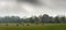 Bales of hay in field on foggy morning