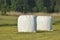 Bales of hay lying on the meadow during haymaking. River Valley surrounded by meadows