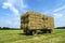 Bales of hay on a trailer standing in a field