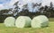 Bales of silage wrapped in white plastic at the green field in s