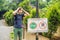 BALI, INDONESIA - 21 May, 2018: Young man looks at protest sign on a wall in Indonesian objecting to Uber and Grab taxi