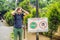 BALI, INDONESIA - 21 May, 2018: Young man looks at protest sign on a wall in Indonesian objecting to Uber and Grab taxi drivers re