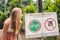 BALI, INDONESIA - 21 May, 2018: Young woman looks at protest sign on a wall in Indonesian objecting to Uber and Grab