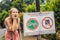 BALI, INDONESIA - 21 May, 2018: Young woman looks at protest sign on a wall in Indonesian objecting to Uber and Grab