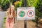 BALI, INDONESIA - 21 May, 2018: Young woman looks at protest sign on a wall in Indonesian objecting to Uber and Grab taxi drivers