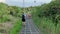 Bali, Indonesia - August, 8, 2022: Man walking along a tiled path in the mountains. Male tourist on a ridge walk road in