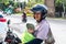 BALI, INDONESIA - JUNE 2, 2017: Portrait of balinese mother with her children in hands sitting on the motorbike