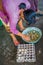 BALI, INDONESIA - MARCH 08, 2017: Women preparing an Indian Sadhu dough for chapati on Manmandir ghat using a turtle