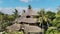 Bali, Indonesia - March 30, 2018: Axel Drone shot portrait of group of tourists in tropical house with straw rooftop
