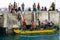 BALI/INDONESIA-MAY 15 2019: Some Balinese traditional boat passengers arrive at the dock and walk to the mainland. They use yellow