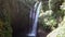 Bali waterfall Aling-aling among green tropical jungle trees, while sunny day