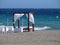 Balinese bed and white armchairs on the beach