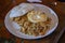 Balinese dinner served in a white plate with mixed seafood friedrice and egg