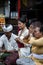 A Balinese family is praying with flowers on their fingers at a temple in Ubud, Bali.