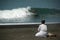 A Balinese lady and a surfer do morning ritual