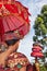 Balinese man in sarong hold umbrella in hindu temple