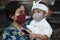 Balinese mother and child are wearing Balinese traditional clothes during the corona pandemic or covid-19. They both use masks to