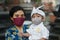 Balinese mother and child are wearing Balinese traditional clothes during the corona pandemic or covid-19. They both use masks to