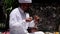 Balinese priest ringing a bell and performs the ritual of remembrance of dead ancestors. Veneration of the dead. Closeup