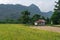 A Balinse ricefield with a hut with mountains in the background