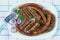 Balkan cuisine . Grilled dish of minced meat - cevapi , kobasica and pljeskavica . Flat lay