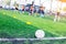 Ball on green artificial turf at side line of football field wit