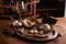 A ball of ice cream in a vintage metal ice-cream bowl on a wooden background with an assortment of cheeses in the background