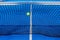 ball impacts against the net of a blue paddle tennis court