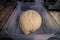 Ball of raw uncooked swiss zopf bread dough rising in a plastic container