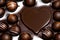 The ball-shaped filled chocolates surround a heart-shaped chocolate plate in the middle.