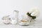 Ball-shaped white hydrangea in a round glass vase, set of light dishes, milk jug, porcelain and enameled cups, a jug for a