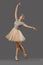 Ballerina in beige dress and ballet shoes dancing in studio